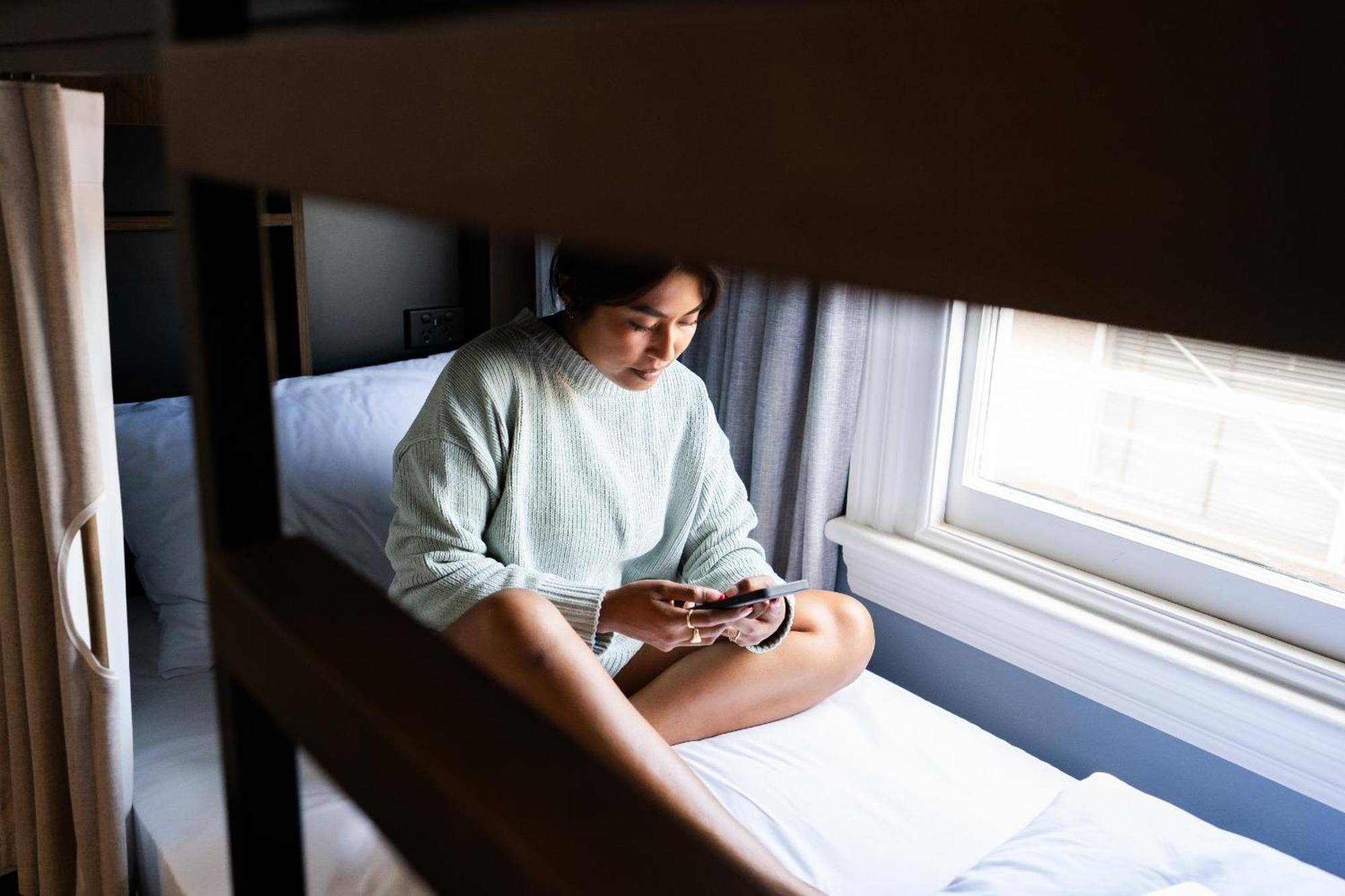 Haka House Christchurch Pokoj fotografie A woman sitting on a bunk bed